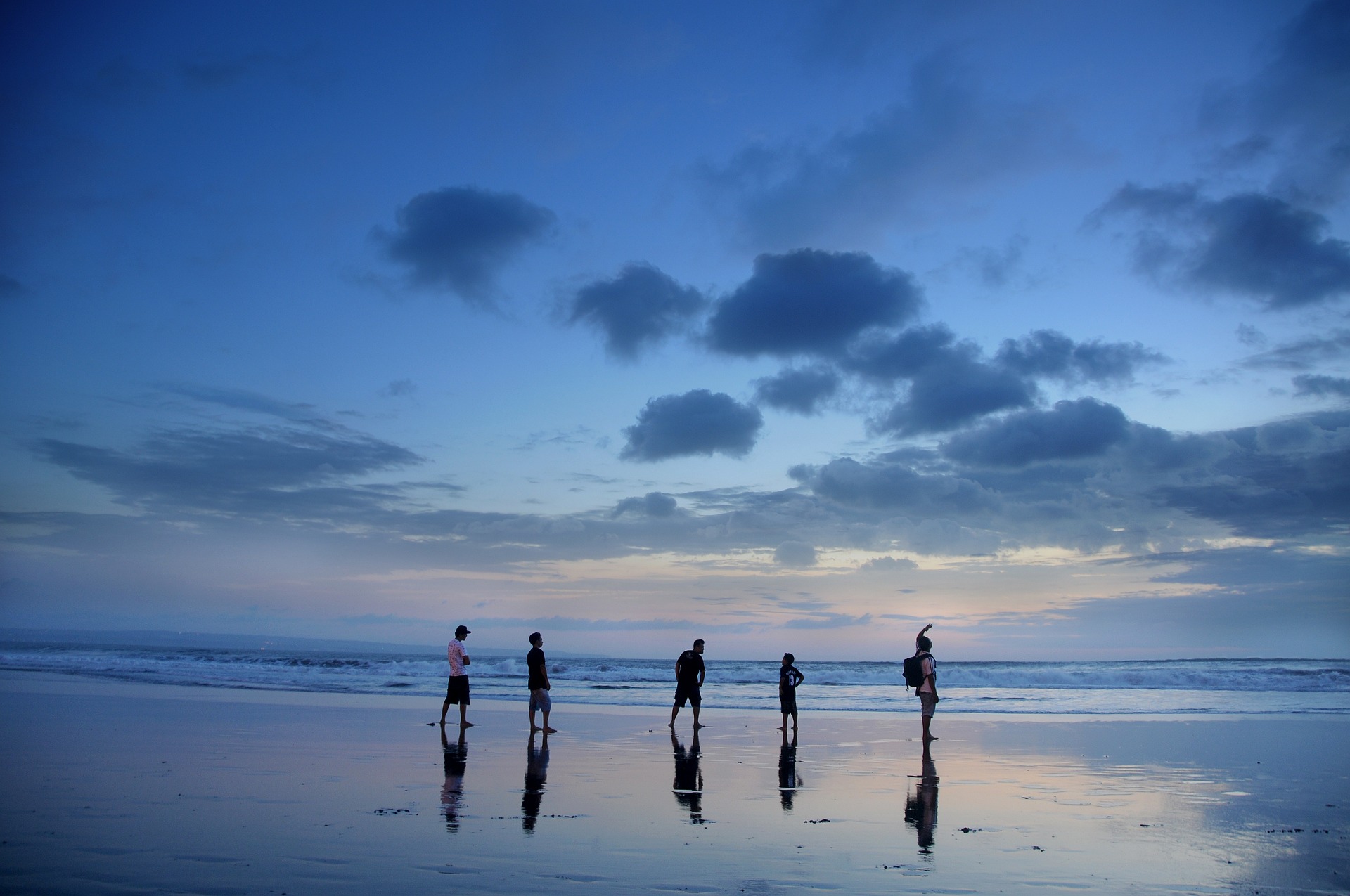 A beach in Bali during dusk, with some peoples playing